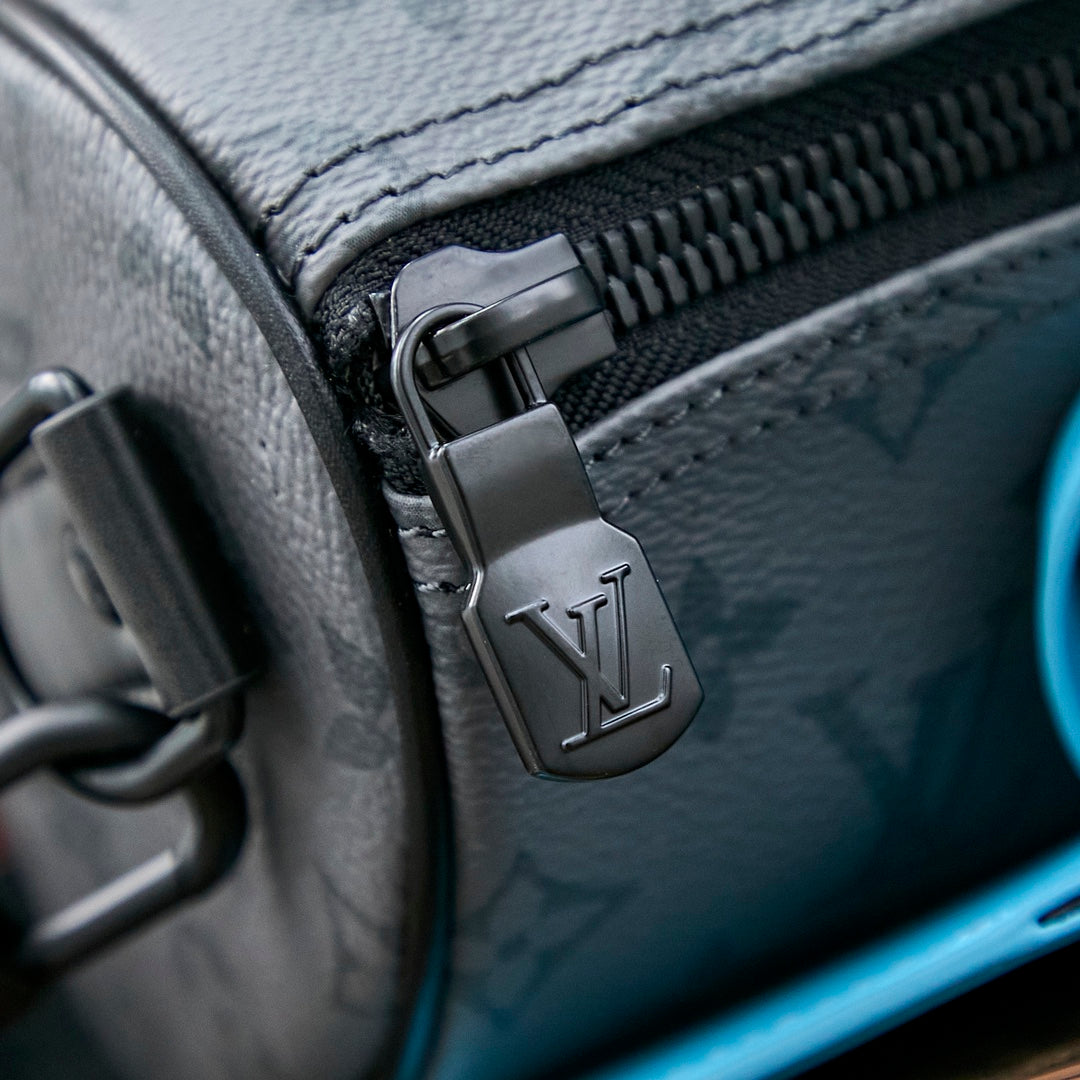 LOUIS VUITTON KEEPALL BANDOULIÈRE 25 IN GUN METAL MONOGRAM ECLIPSE CANVAS MIX TURQUOISE CALFSKIN